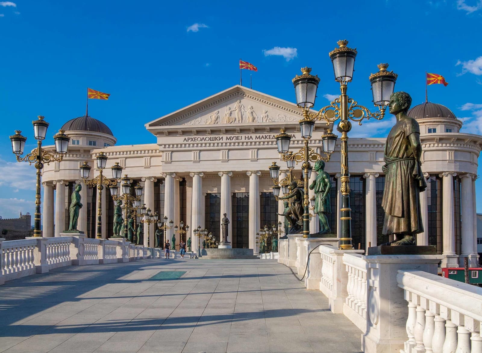 Archaeological Museum of Macedonia in Skopje with neoclassical columns, statues, and street lamps