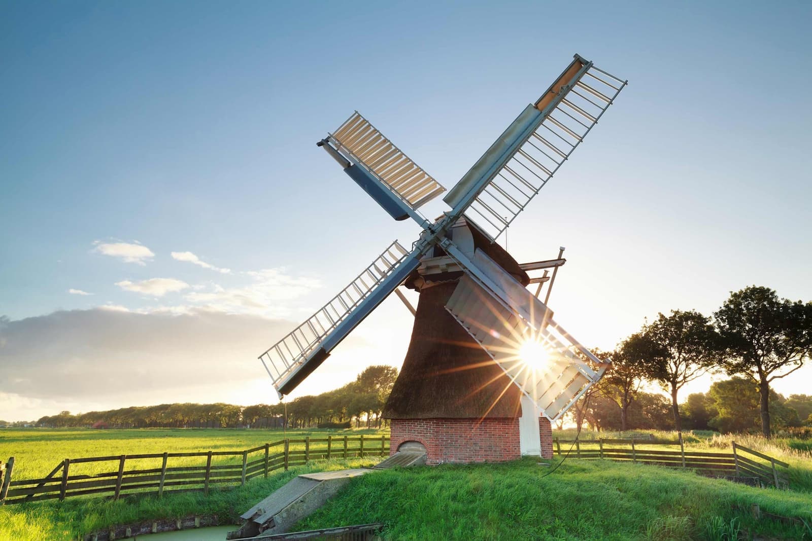 Traditional Dutch windmill standing in green field