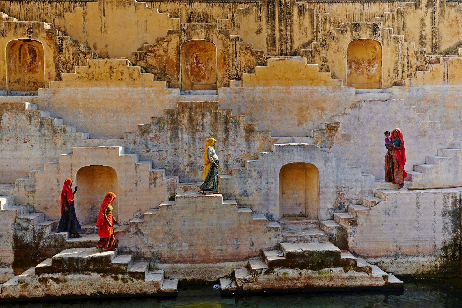 Locals in traditional Rajasthani clothes near rainwater tank, Jaipur, India
