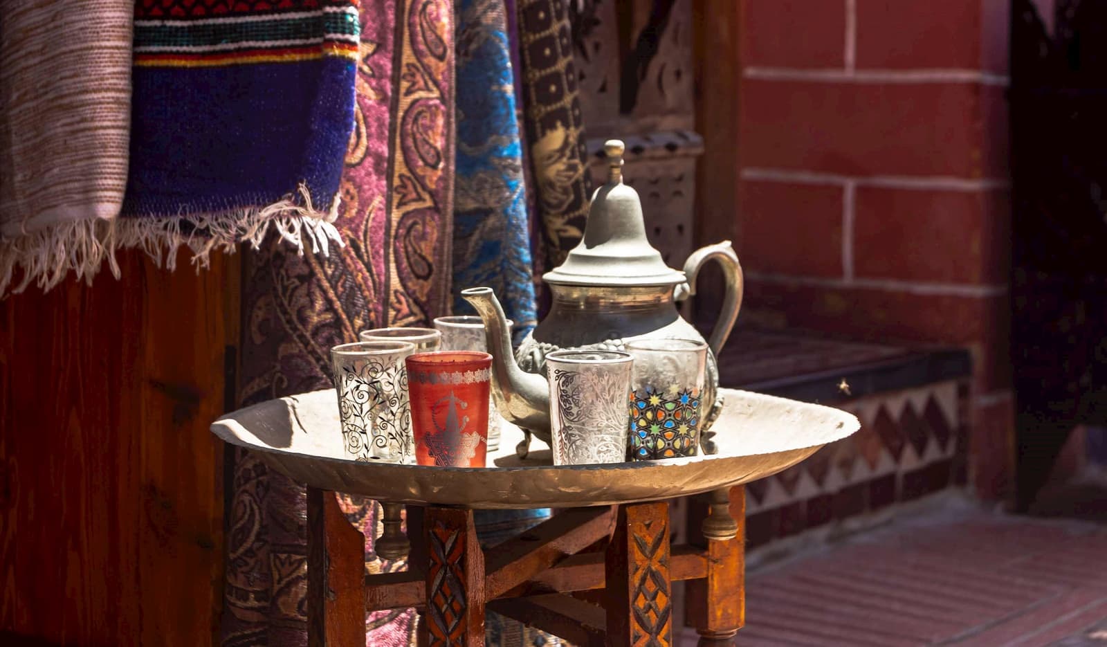 Traditional Moroccan tea set on a wooden table with rugs, Casablanca, Morocco