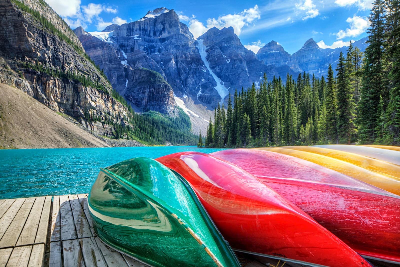 colourful canoes on the deck of Moraine Lake in Banff, Canada
