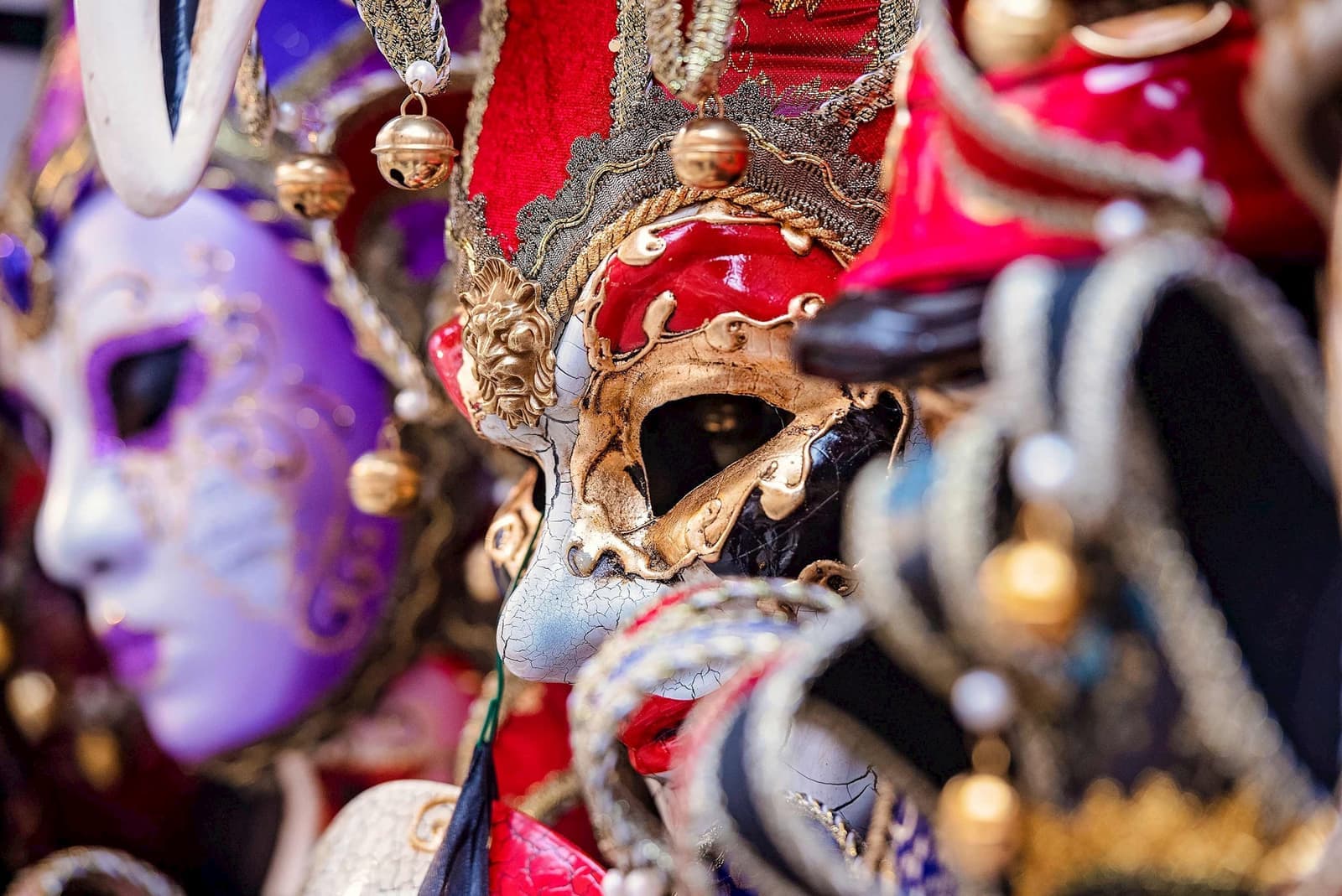 Close-up of Venetian carnival mask with colourful detailing, gold accents and embellishment