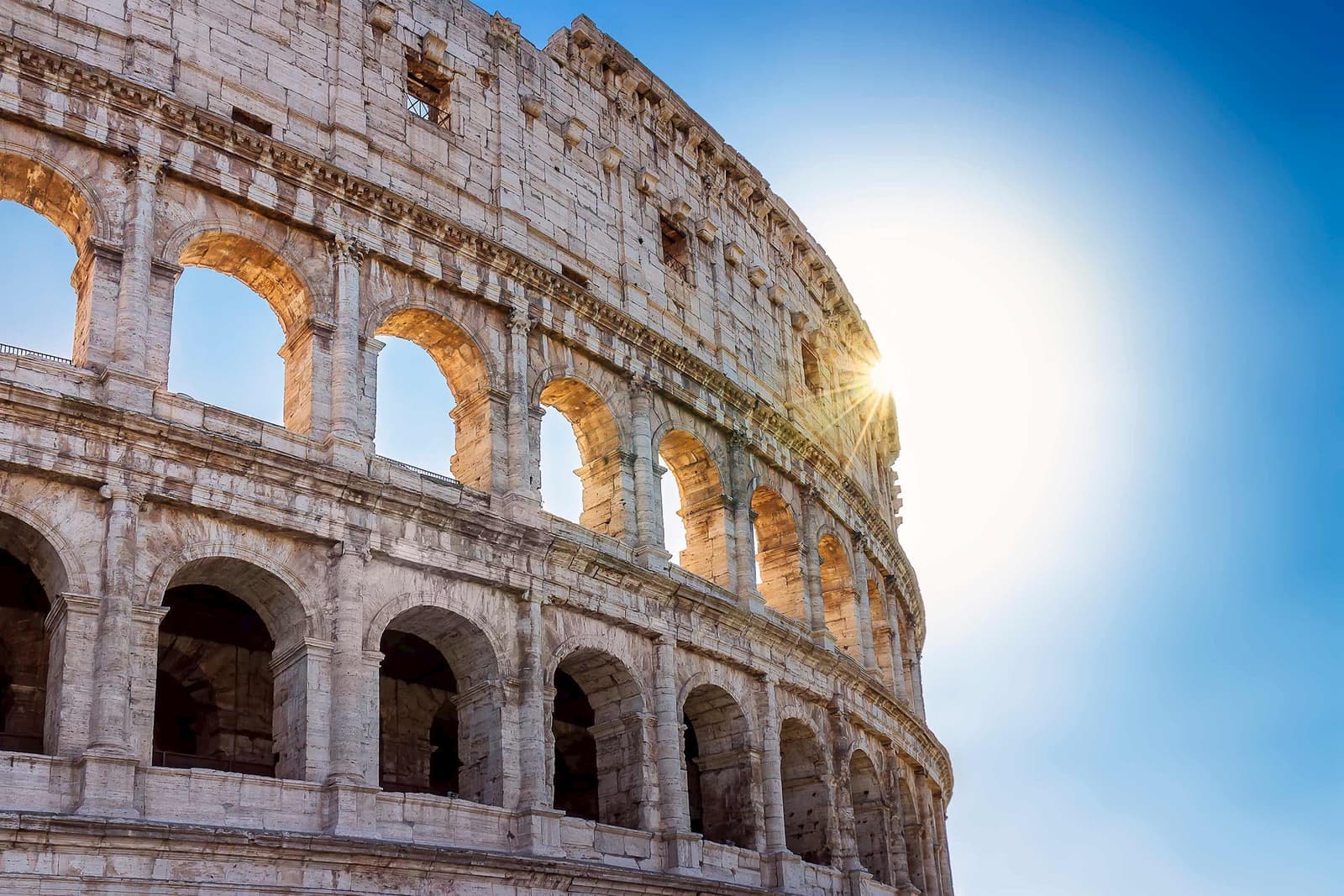 The sun shining through part of the Colosseum in Rome, Italy