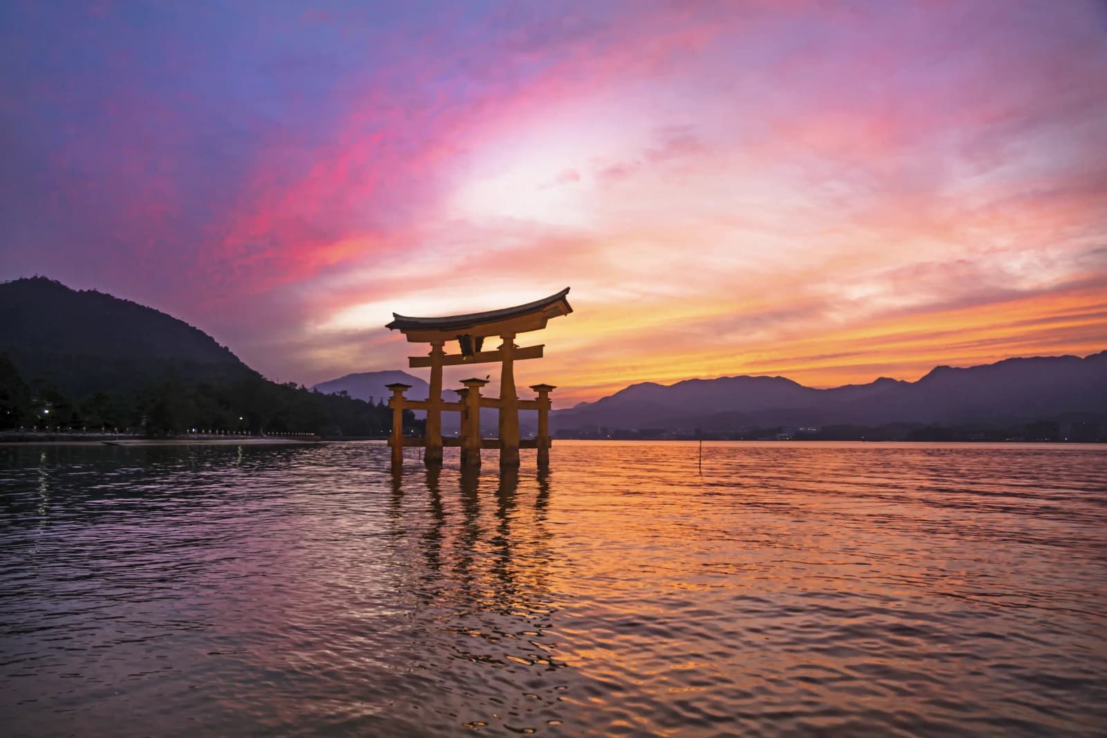 Itsukushima Shrine torii gate in Miyajima, Hiroshima, Japan at sunset.