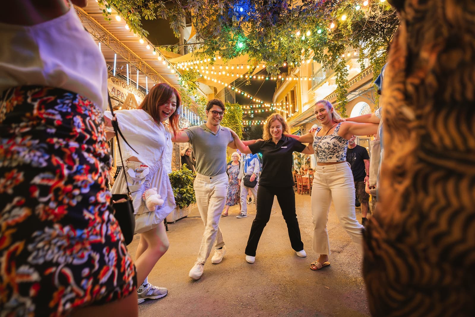 Travellers dancing in a circle at a restaurant in Athens, Greece