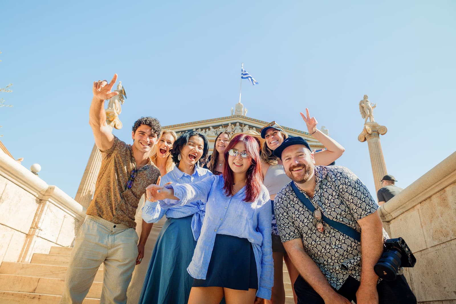 Travellers posing for a photo with the ancient ruins in the background in Athens, Greece
