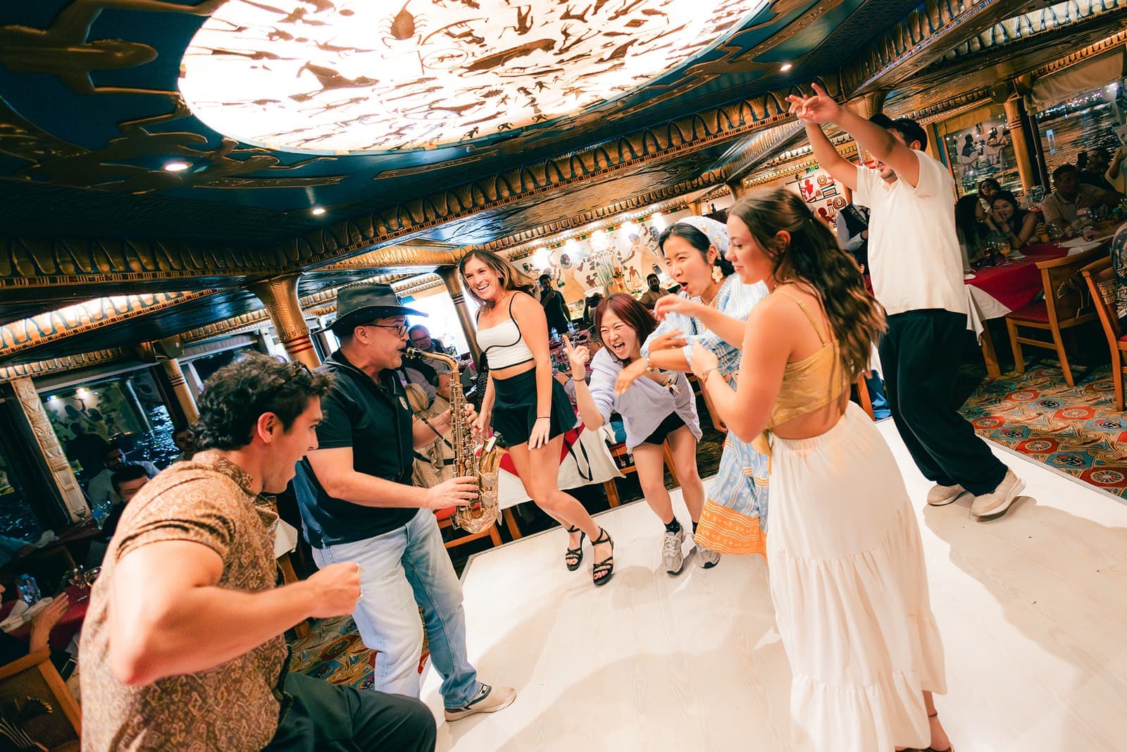Travellers dancing in a circle around someone playing the saxophone in Cairo, Egyot