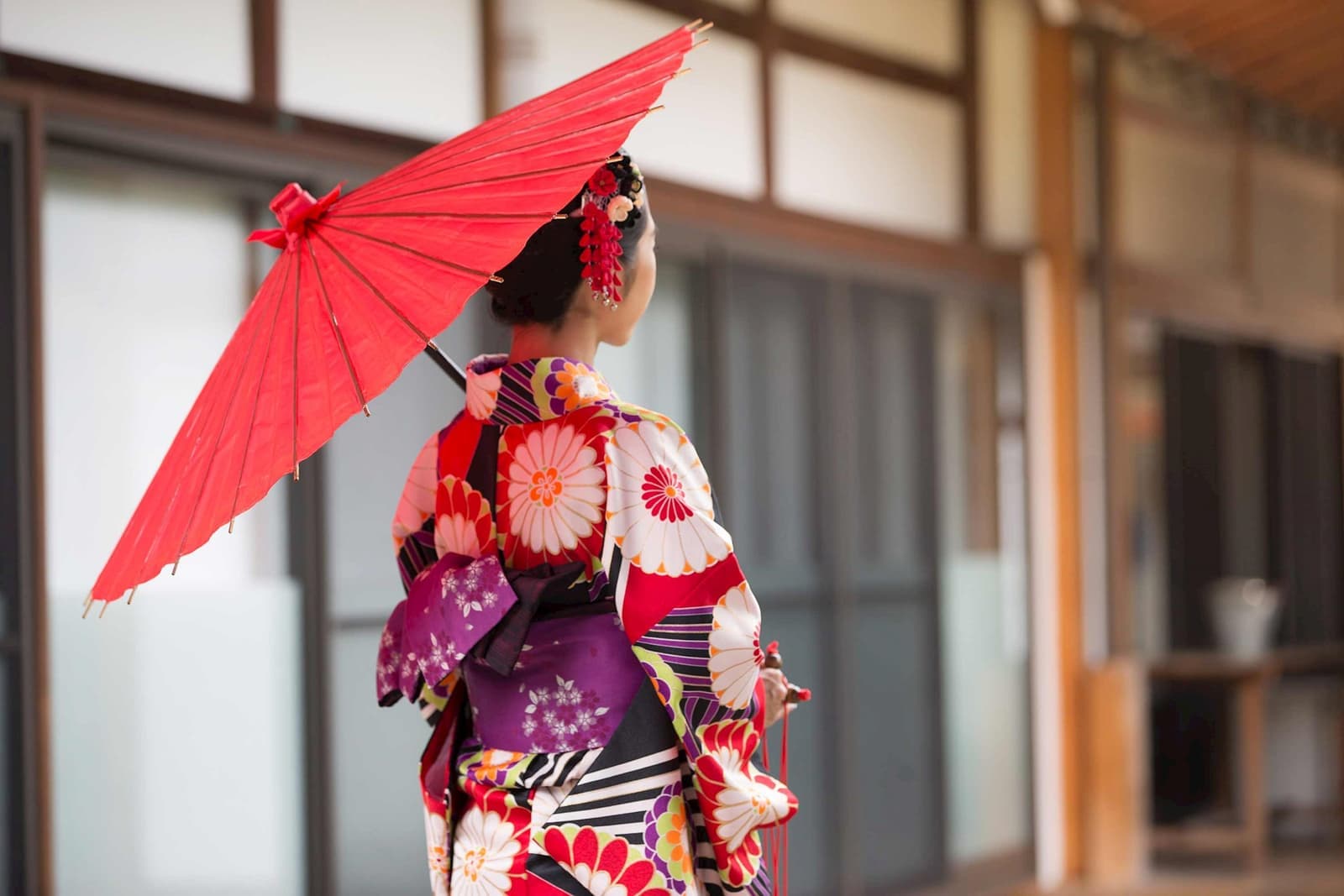 Woman in kimono holding red umbrella at Hyakumanben Chionji Temple, Kyoto