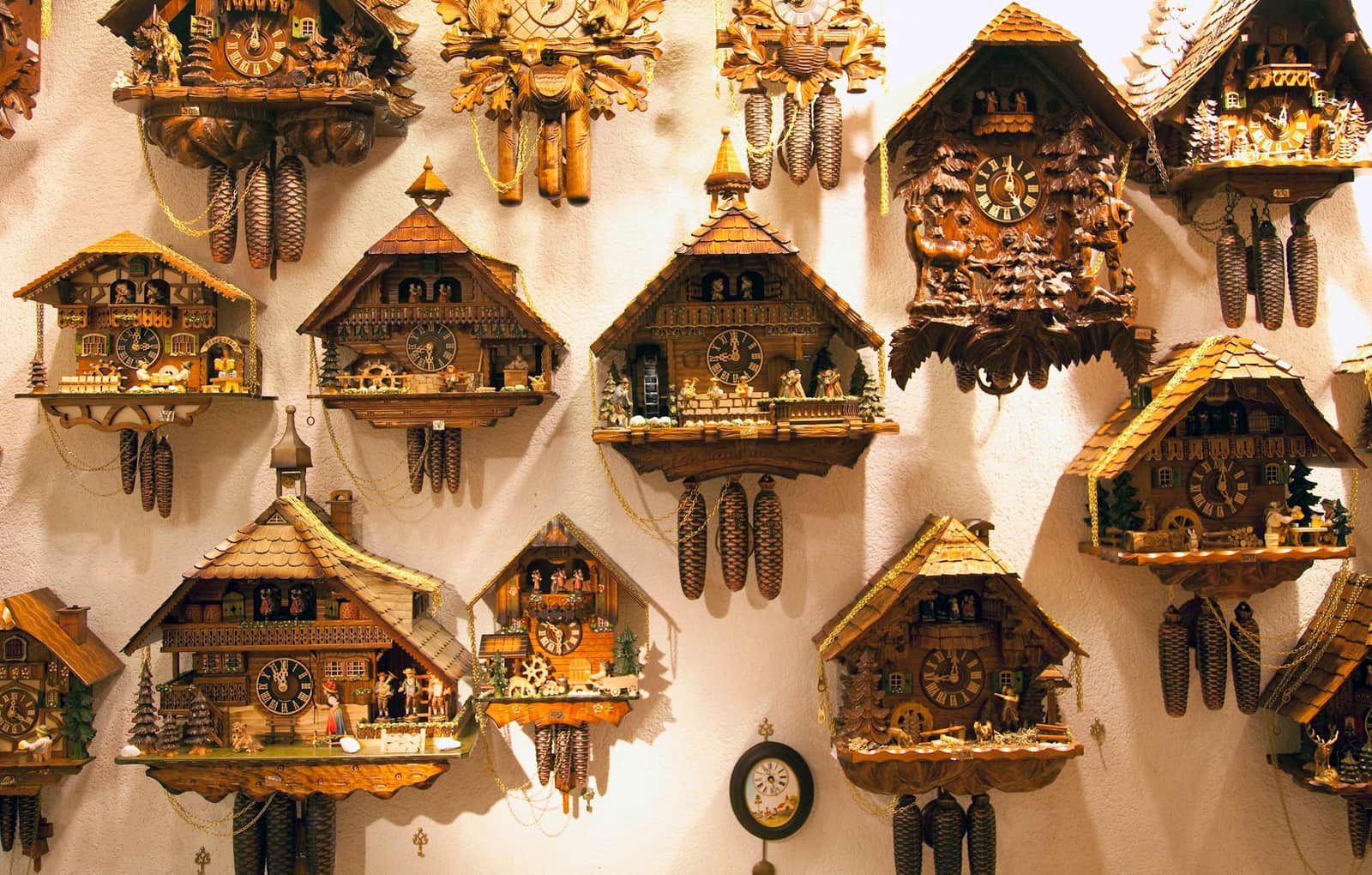 A group of cuckoo clocks on a wall in the Black Forest, Germany