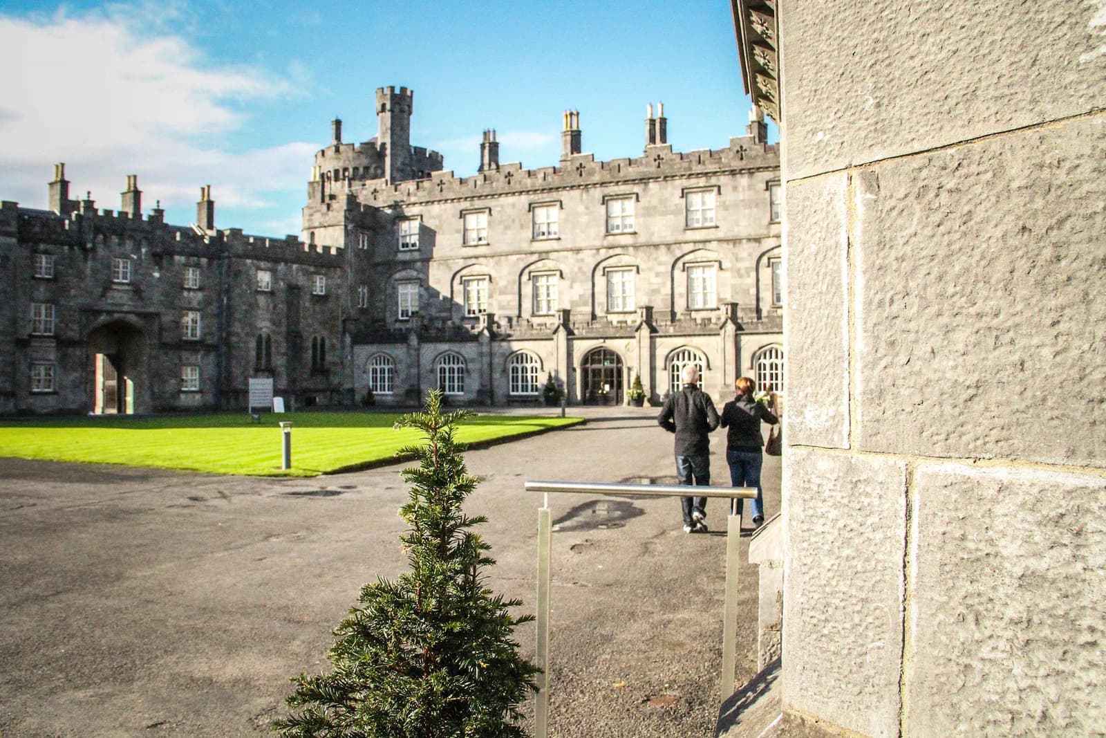 Kilkenny Castle with towers, arched windows and visitors