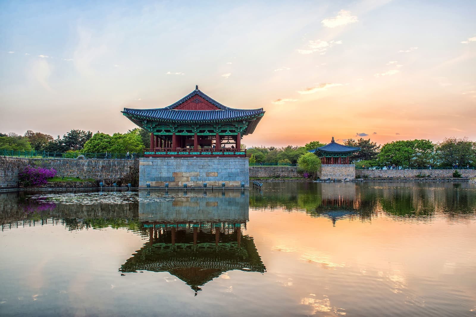 Sunset view of Donggung Palace reflected in calm water of Wolji Pond, Gyeongju, South Korea