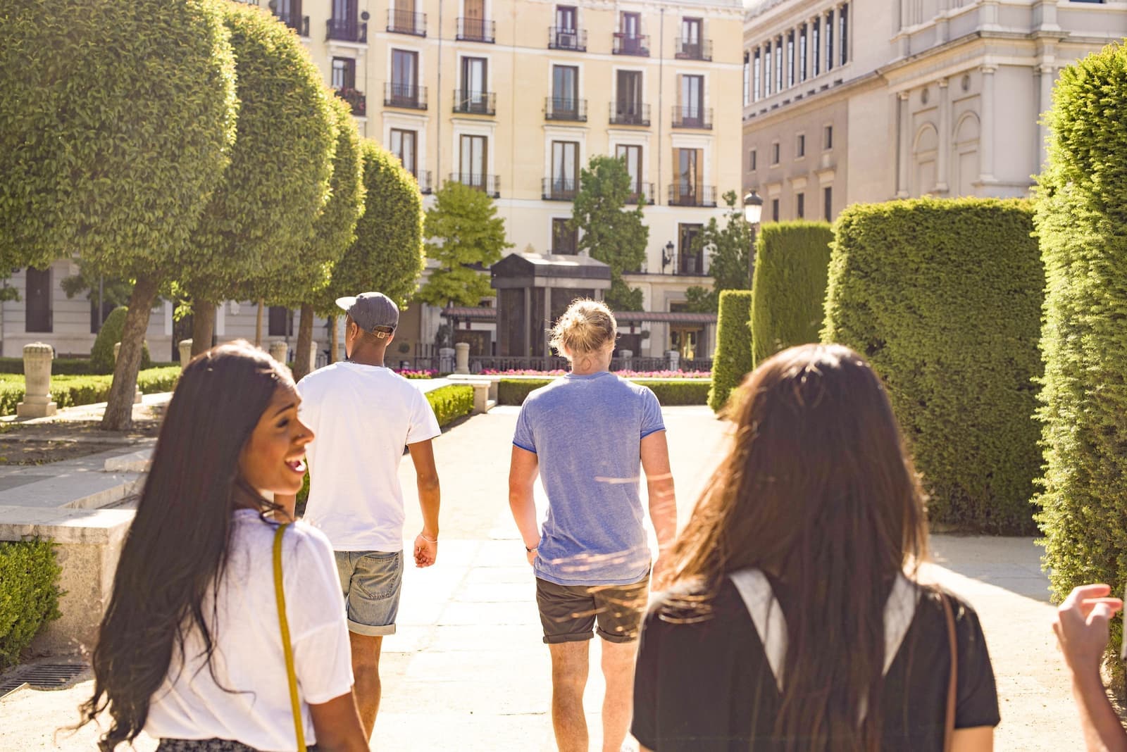 Travellers walking through Plaza de Oriente next to the Royal Palace in Madrid, Spain