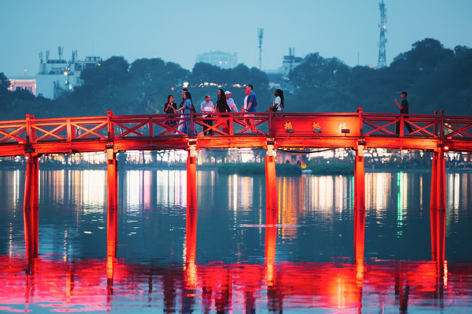 Travellers walking across a bridge in Hanoi, Vietnam