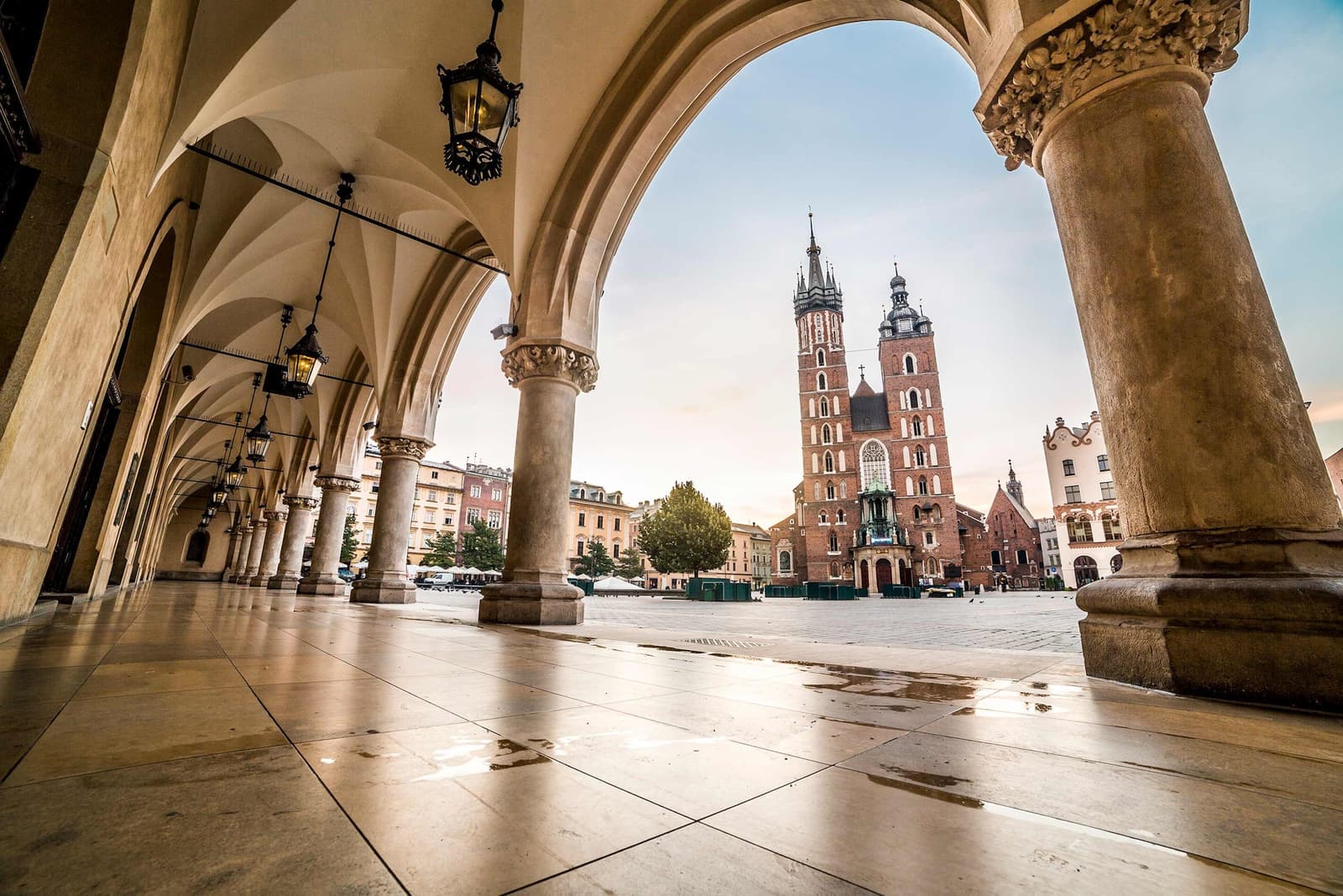 St. Mary’s Basilica framed by Cloth Hall arches at sunrise in Kraków, Poland