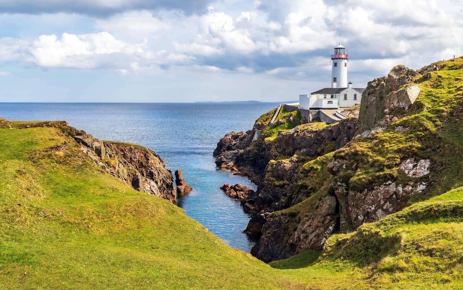 Lighthouse overlooking cliffs against clear skies in Donegal, Ireland