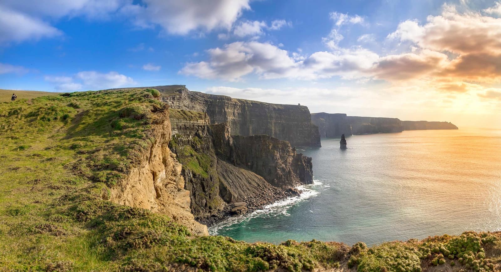 Cliffs of Moher with Atlantic Ocean view and grassy edge at sunset