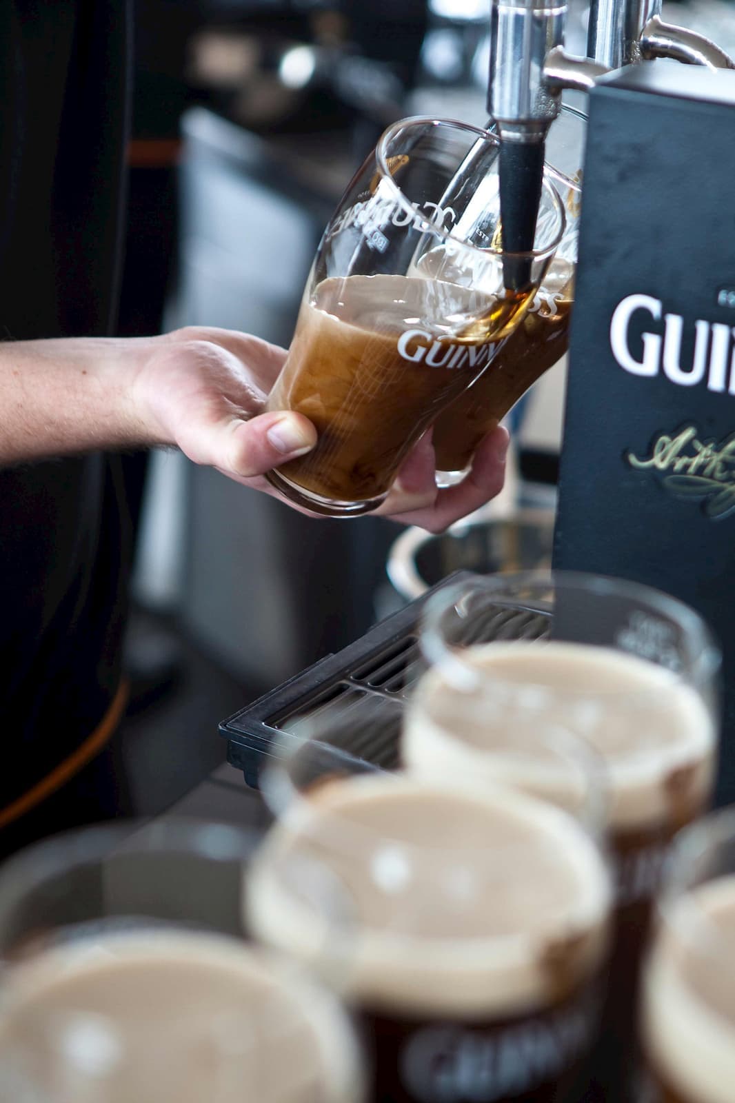 A person pouring a glass of Guinness in the Guinness Storehouse in Dublin