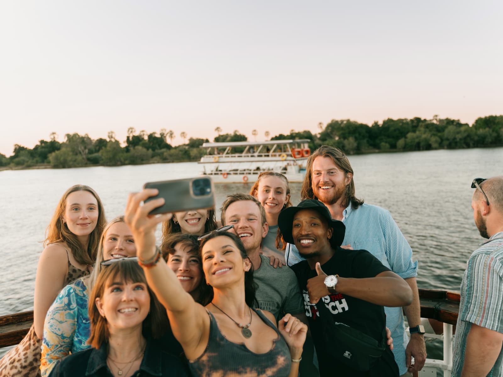 Travellers taking a selfie during sunset cruise along the Zambezi River, Zambia