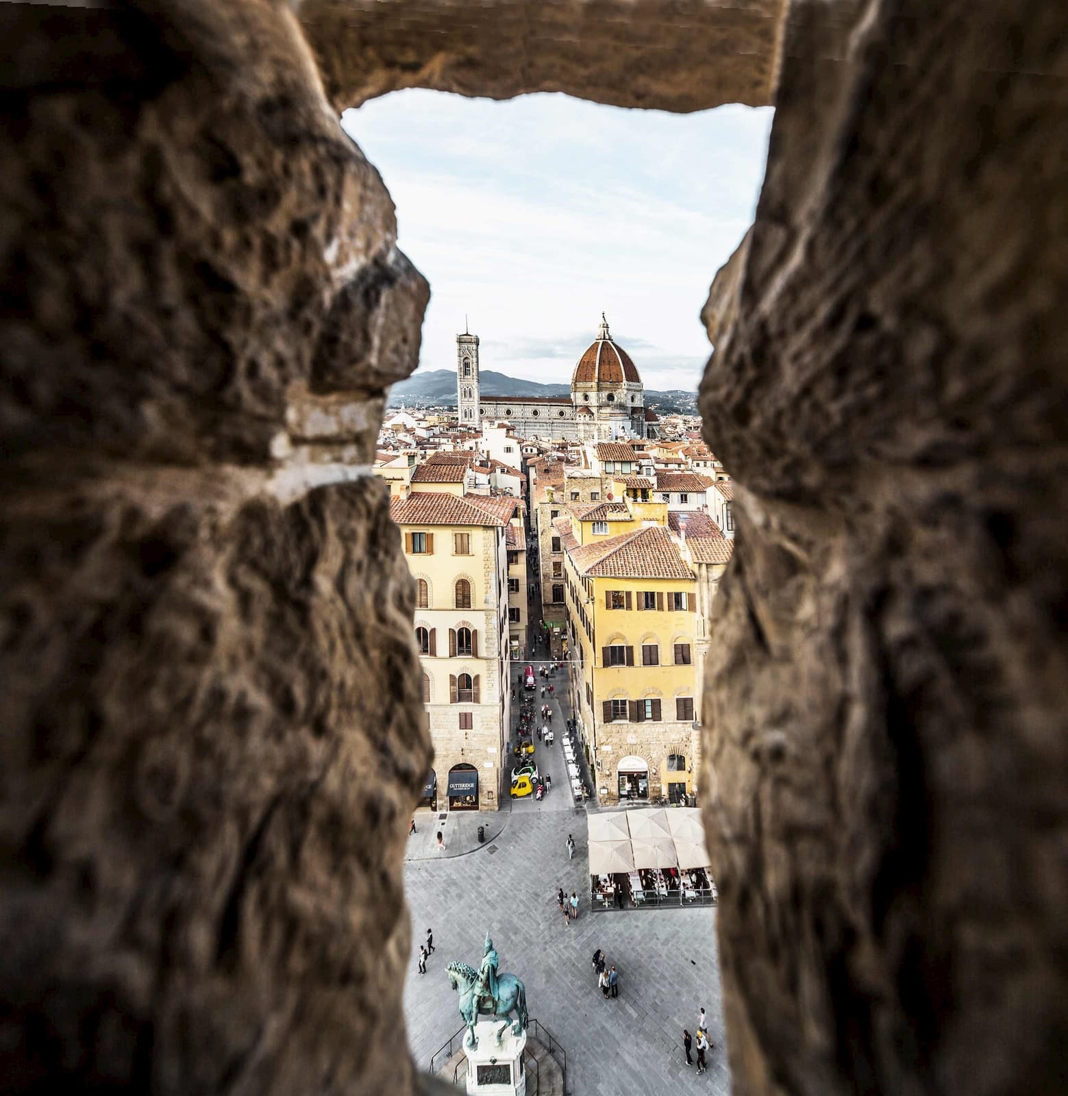 A view of Florence, Italy through a small hole in a rock wall
