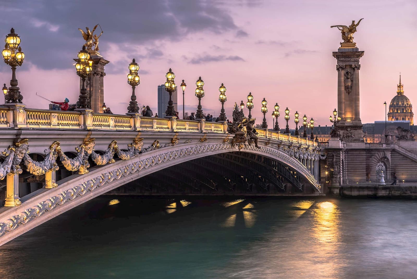 An evening view of the Pont Alexandre III Bridge in Paris, France