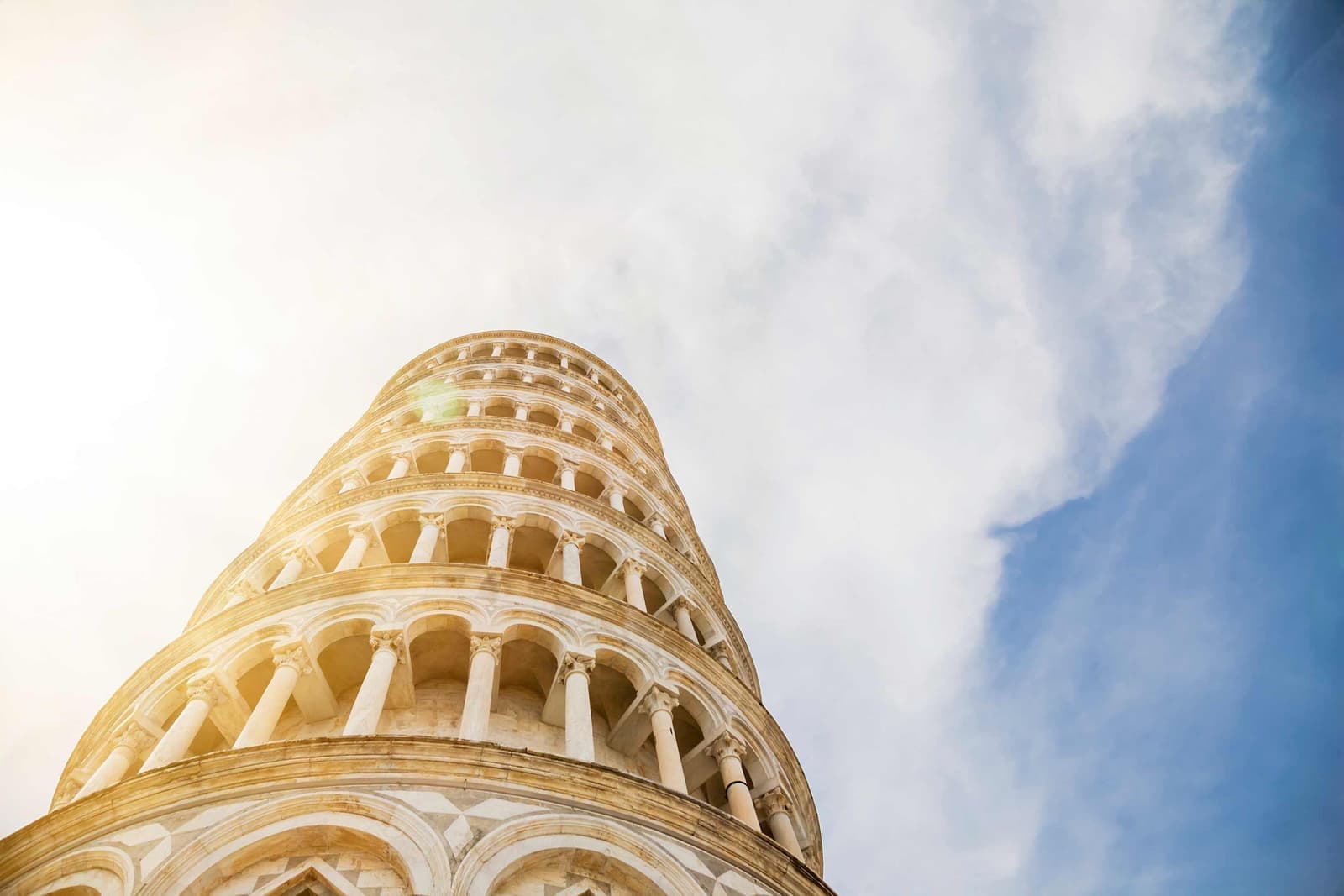 Leaning Tower of Pisa viewed from low angle with cloudy sky