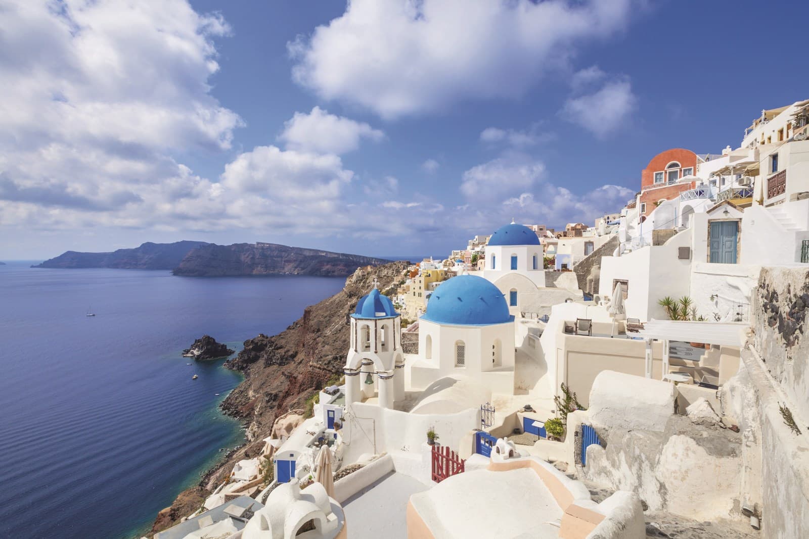 Greek church with three blue domes in the village of Oia, Santorini, Greece