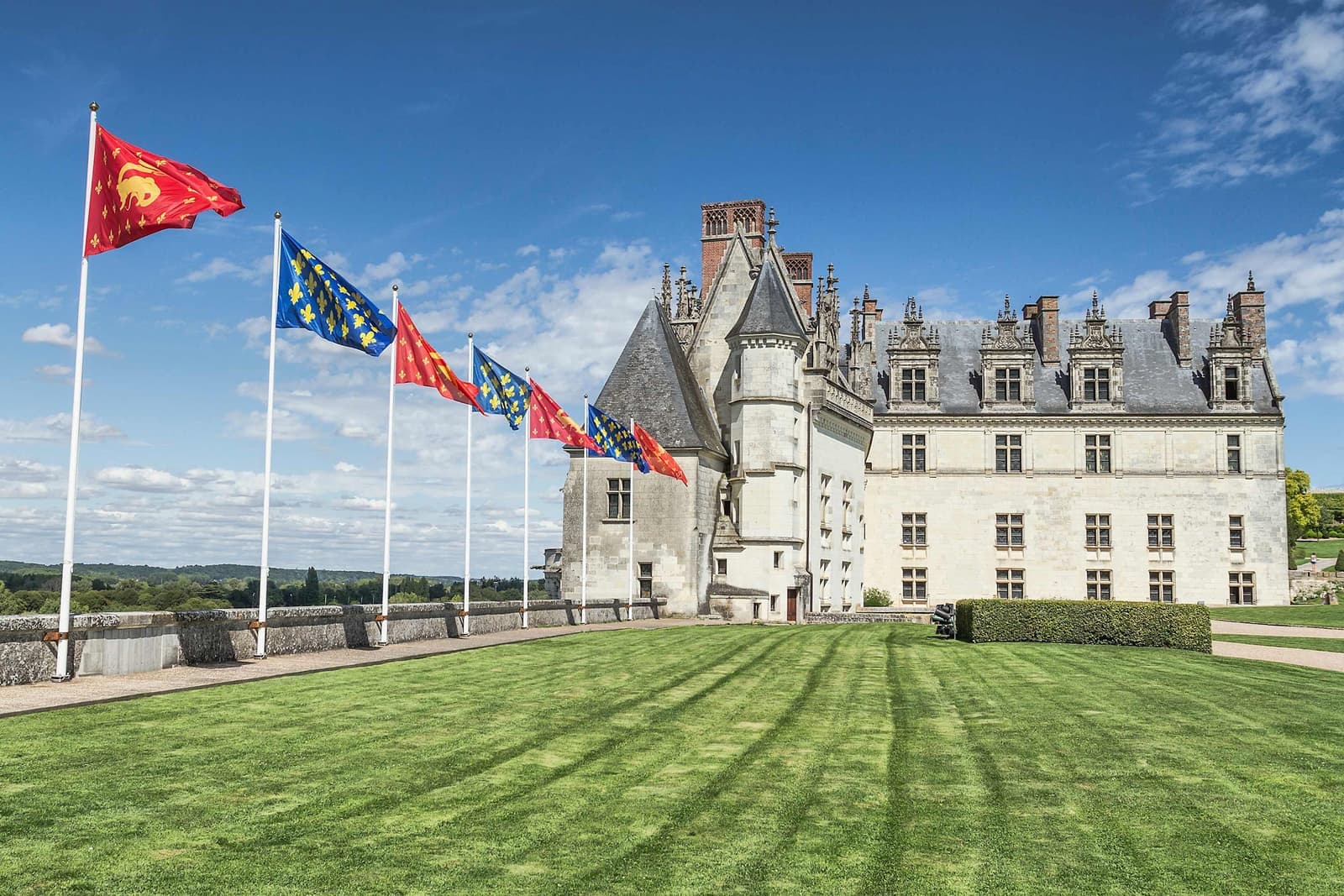A historic Chateau with vibrant flags under the blue sky in Loire Valley, France