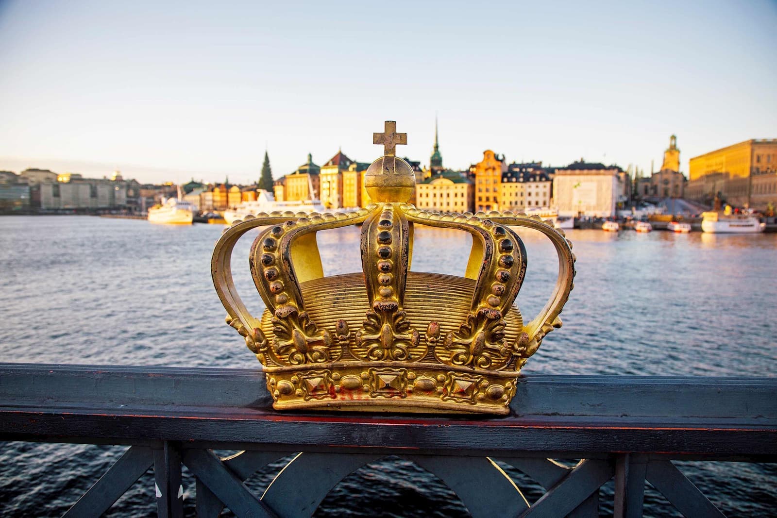 Golden crown placed on bridge railing overlooking waterfront in Stockholm, Sweden