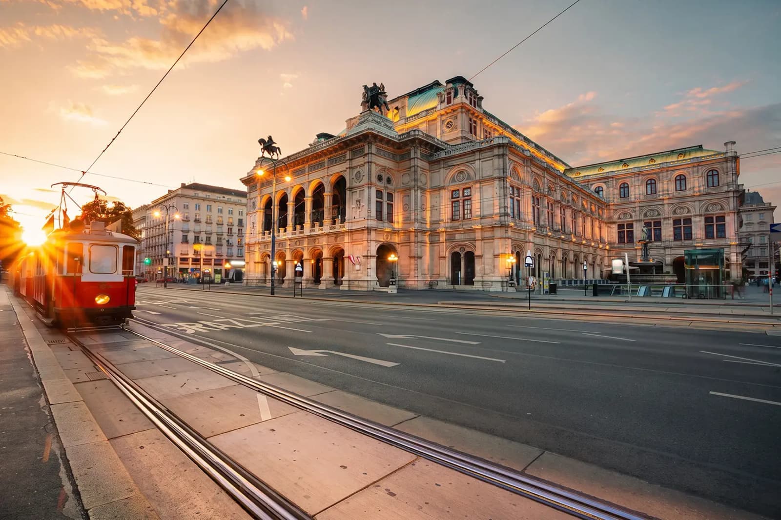 Vienna State Opera in Vienna, Austria, with a red tram traveling past the building.