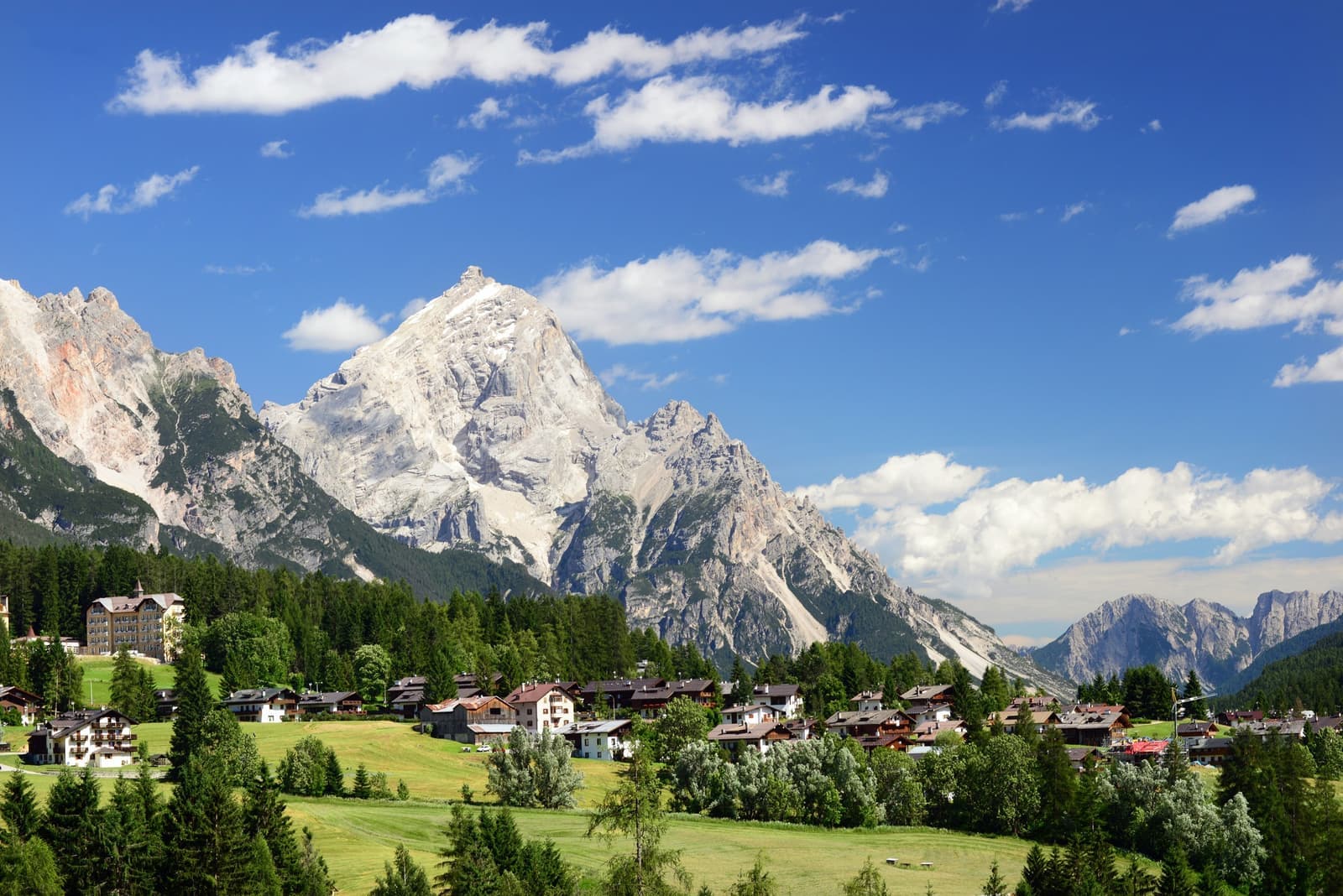 Houses spread in the fields of Cortina d'Ampezzo with mountains at the backdrop, Dolomites, Italy