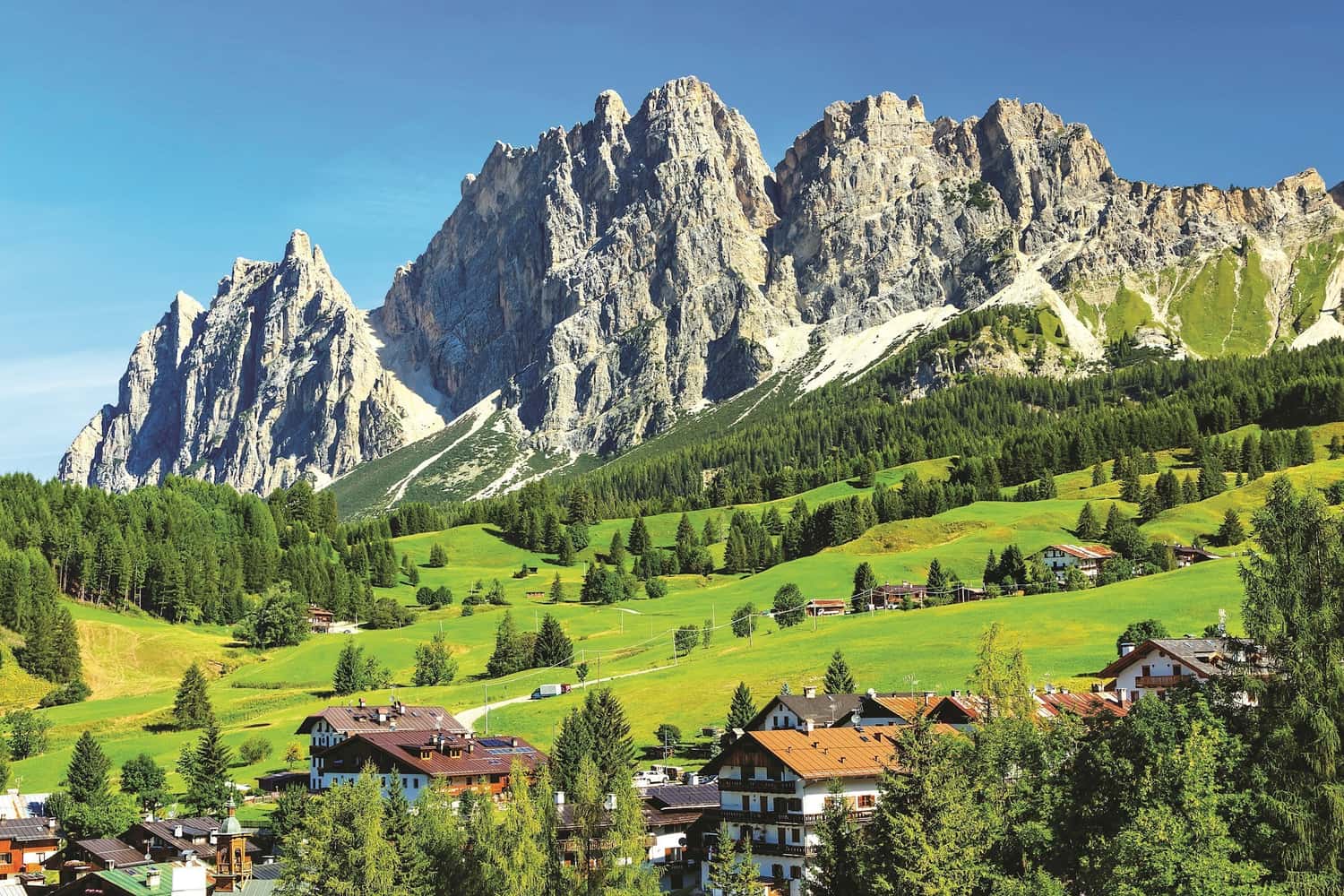 Panoramic view of mountains and settlement in green hills, Cortina di Ampezzo, Italy