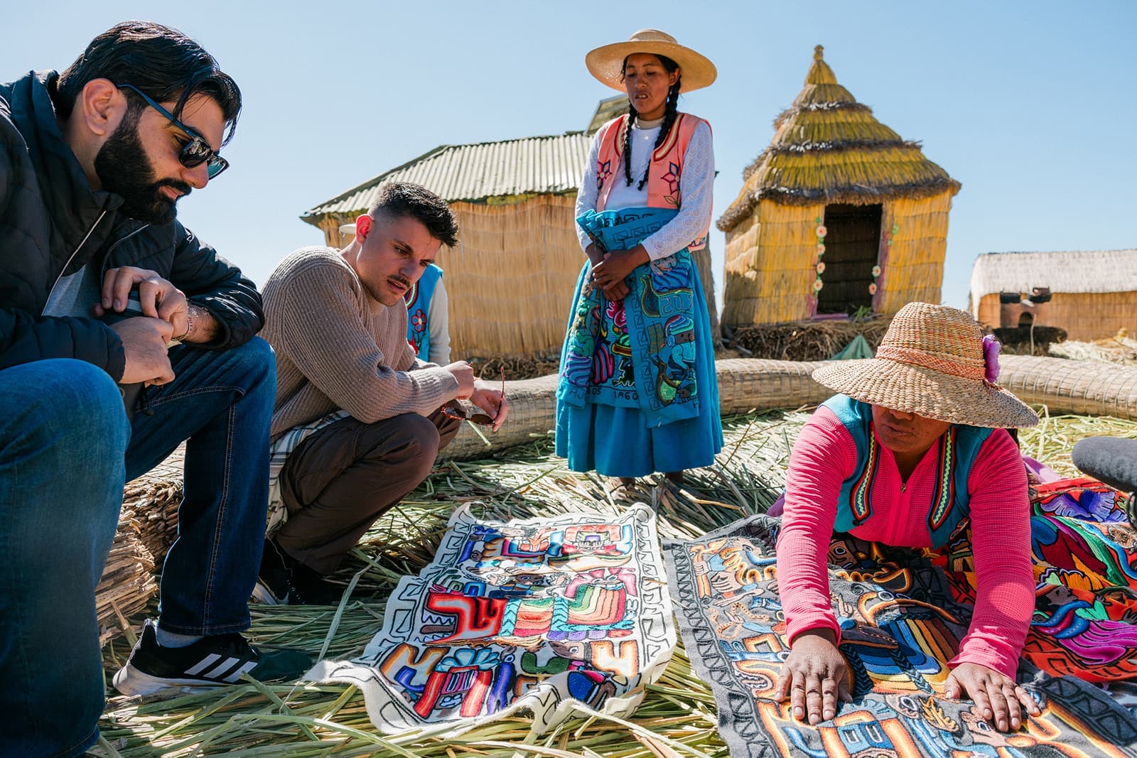 Local resident demonstrating textiles to travellers, Lake Titicaca, Peru