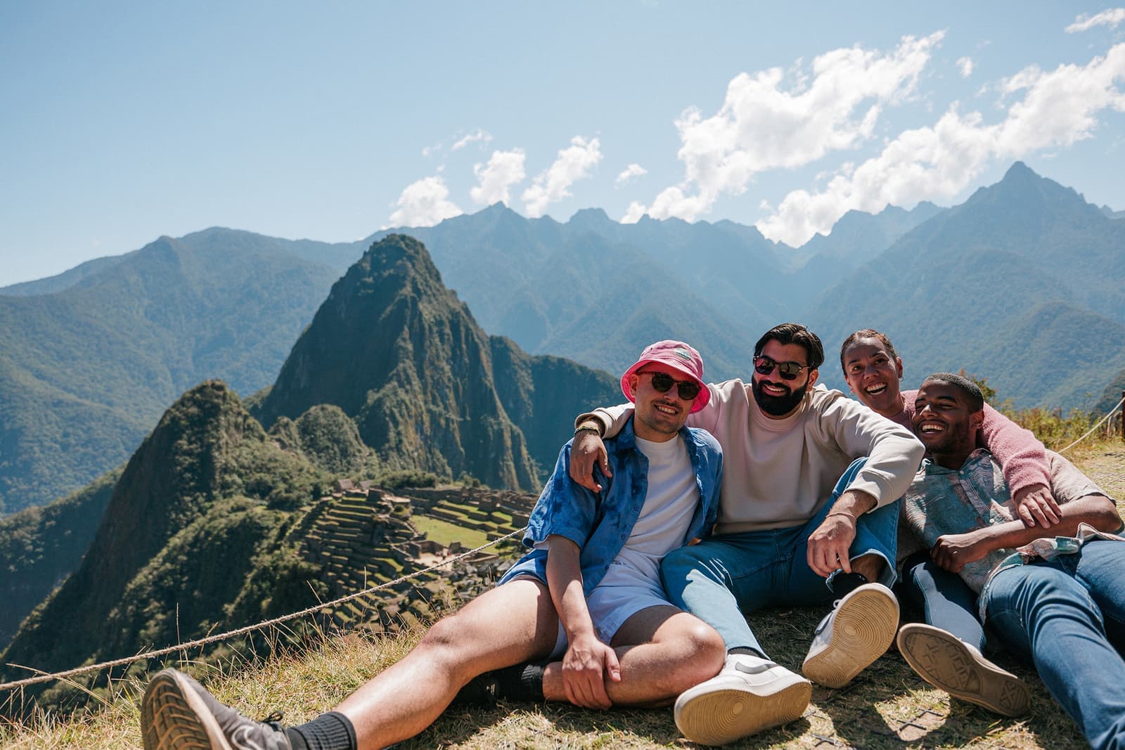 Travellers sat on a viewpoint overlooking Machu Picchu, Peru