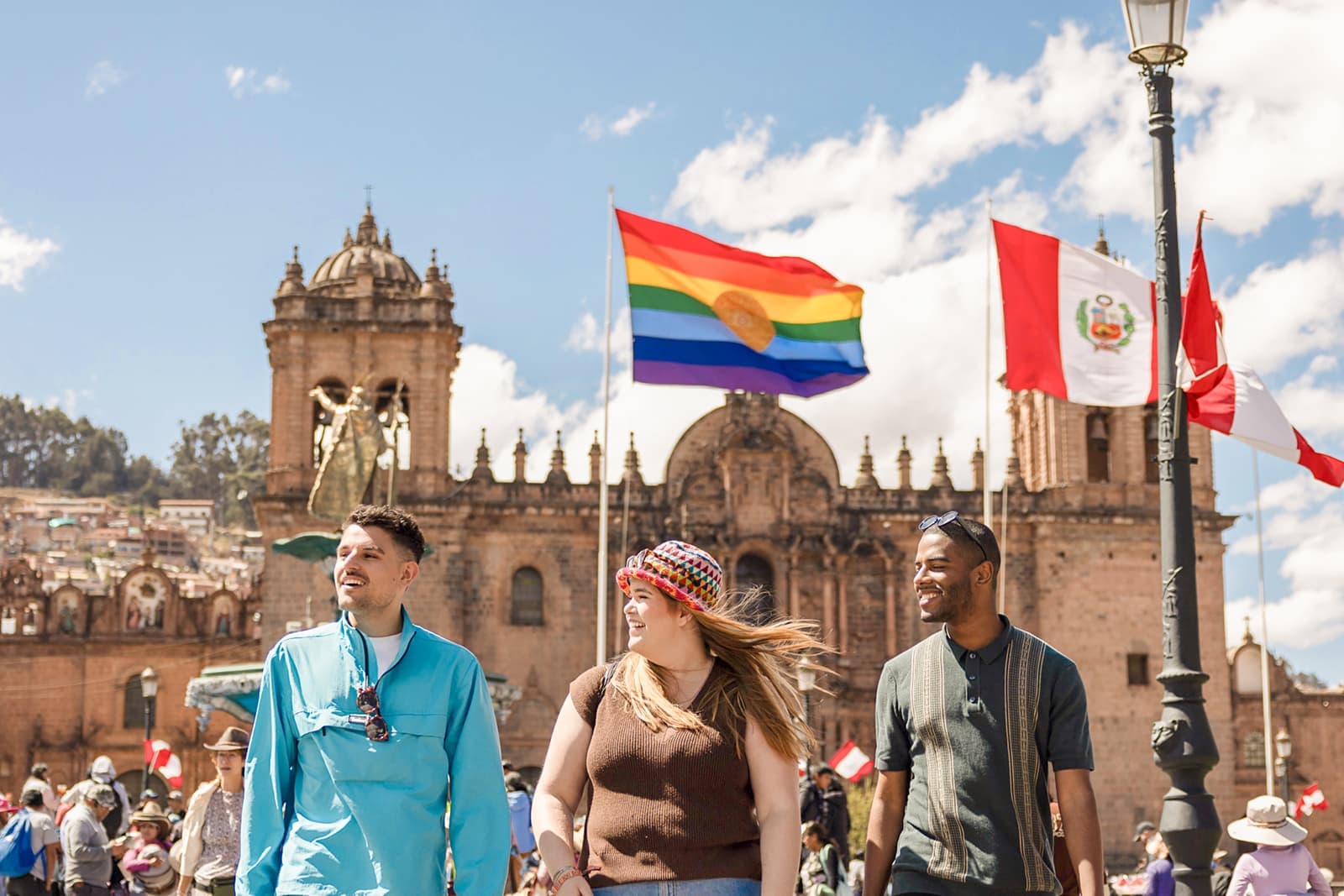 Three travellers standing in front of Plaza Mayor de Cusco in Cusco, Peru