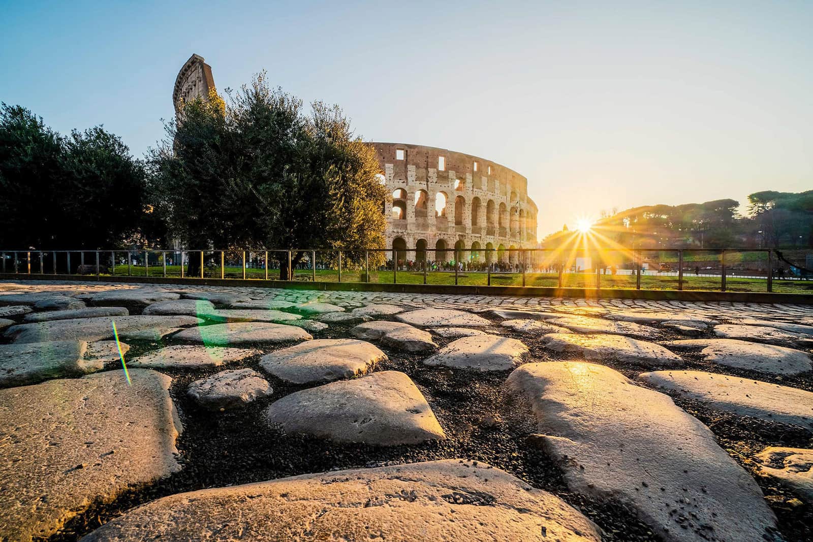 Close view of the Colosseum with sun rays shining through ancient stone in Rome, Italy