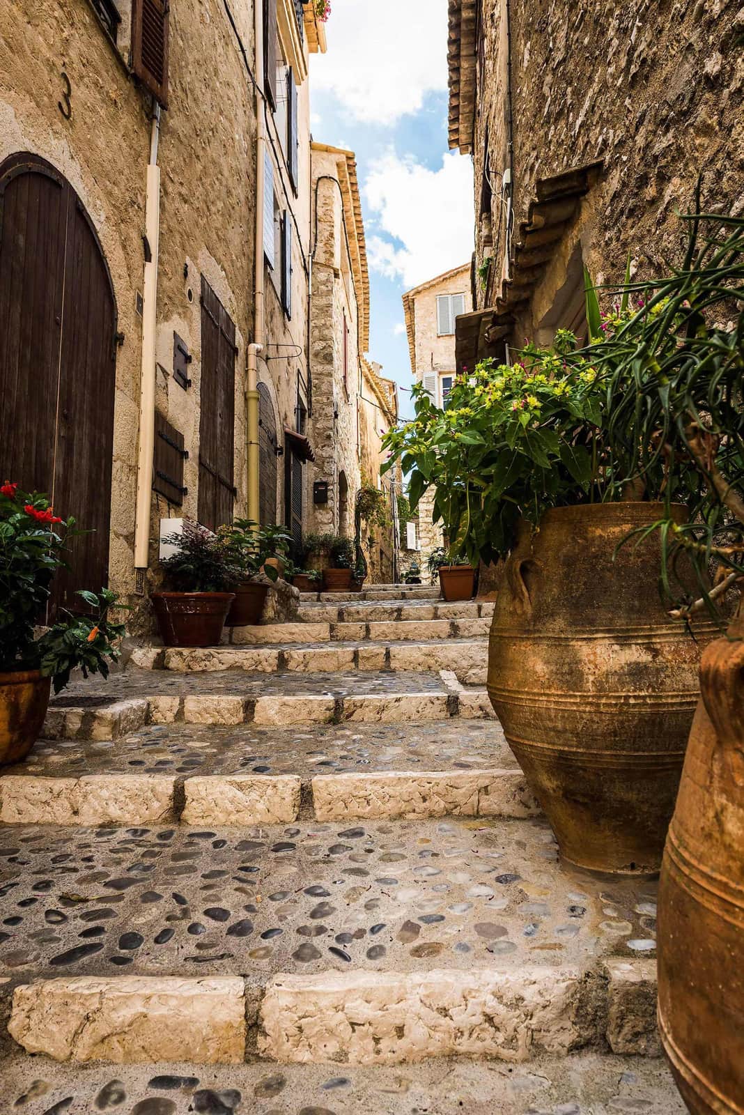 Stone alley with steps, flowers and buildings in Saint Paul De Vence, France