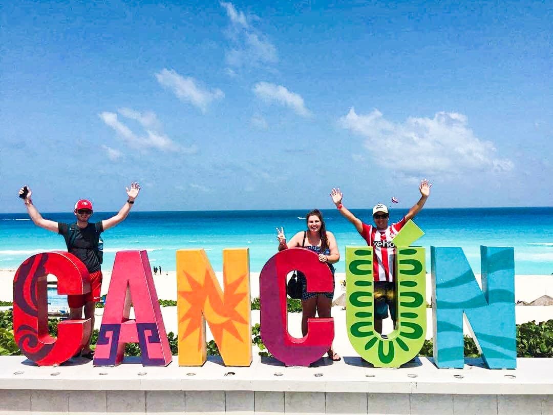 Travellers at a Cancun sign in Cancun, Mexico