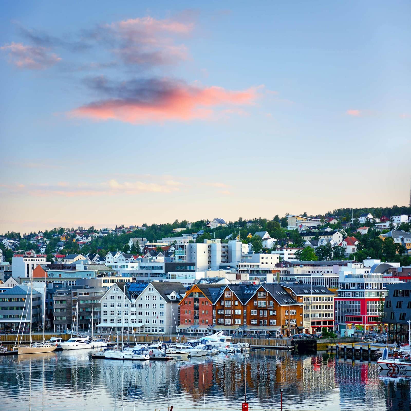 Tromsø harbour with colourful waterfront buildings, boats and hillside houses