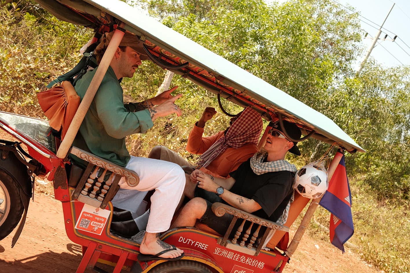 Travellers Enjoying a Ride in a Red Tuk Tuk, Cambodia