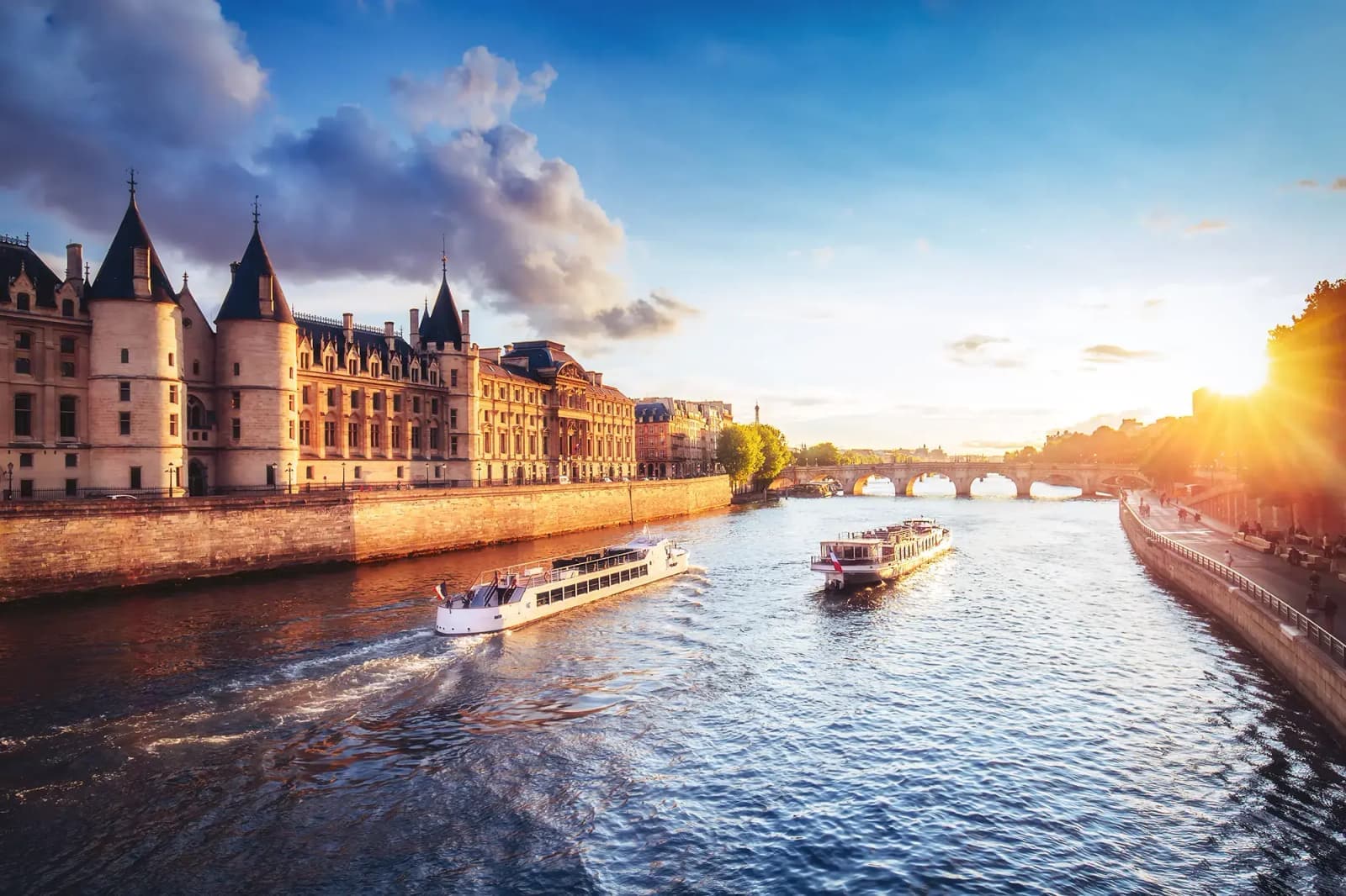 Boats on the Seine River in Paris, France, with bridges spanning the river in the background.