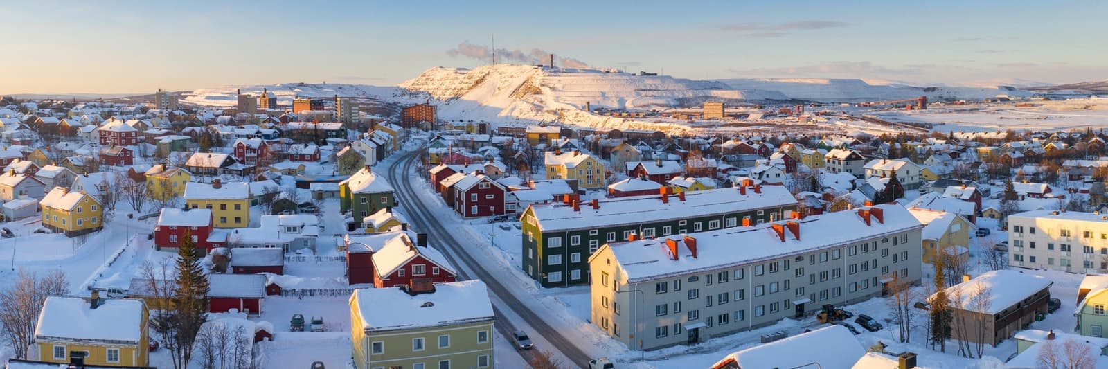 Snowy Kiruna town with colourful houses and distant mining area
