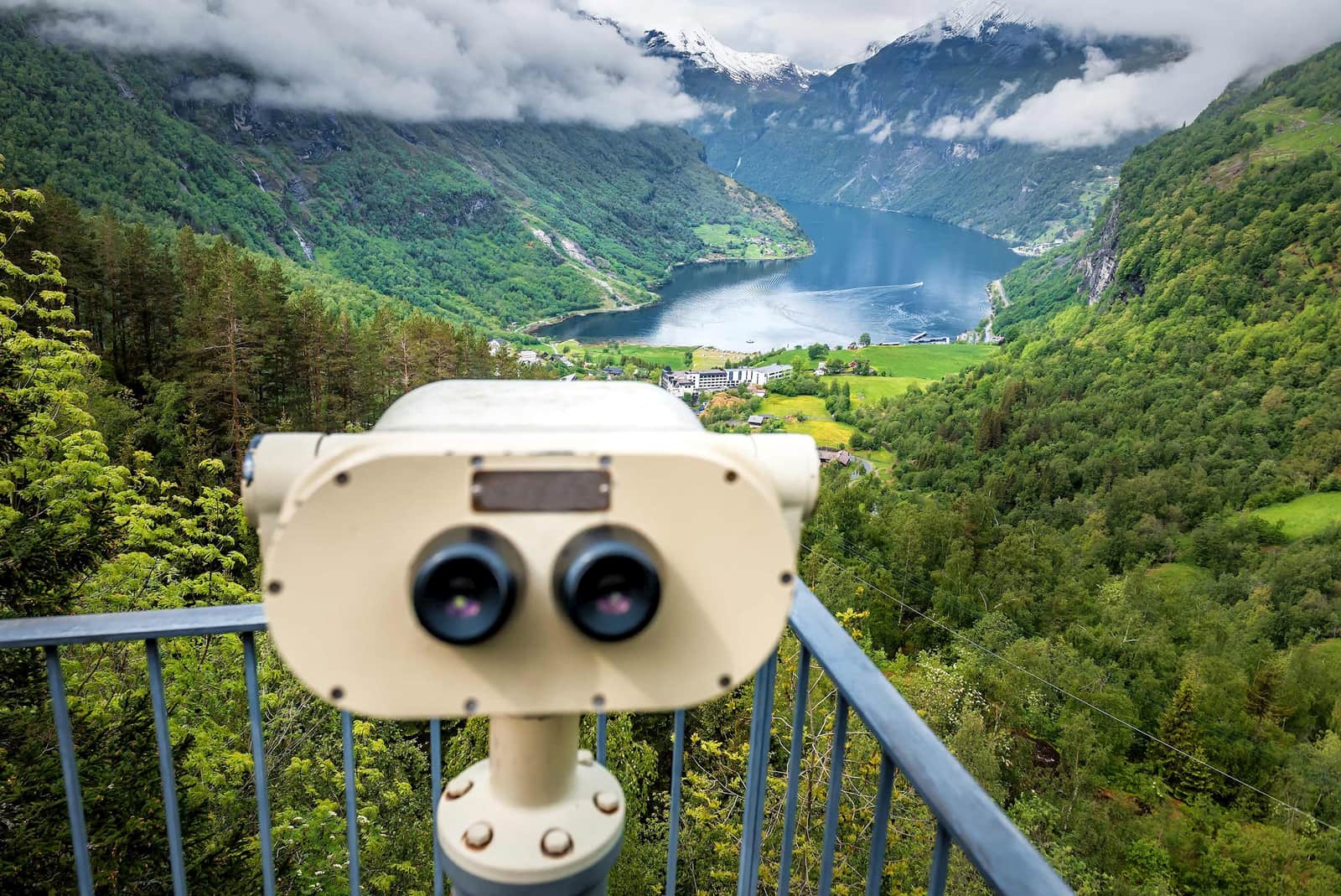 A close-up of a pair of binoculars looking towards Geirangerfjord