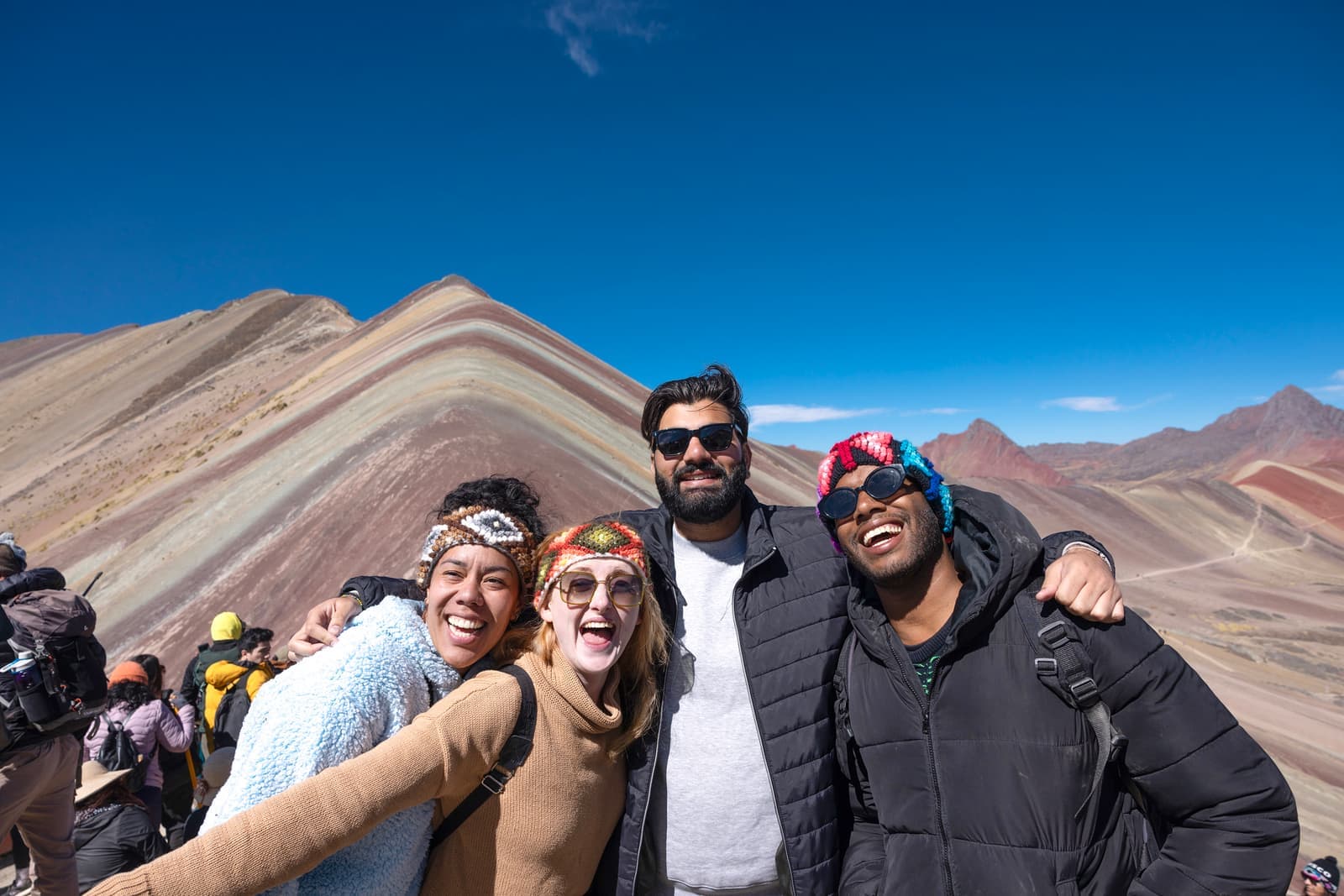 Travellers standing in front of the Rainbow Mountain in Cusco, Peru