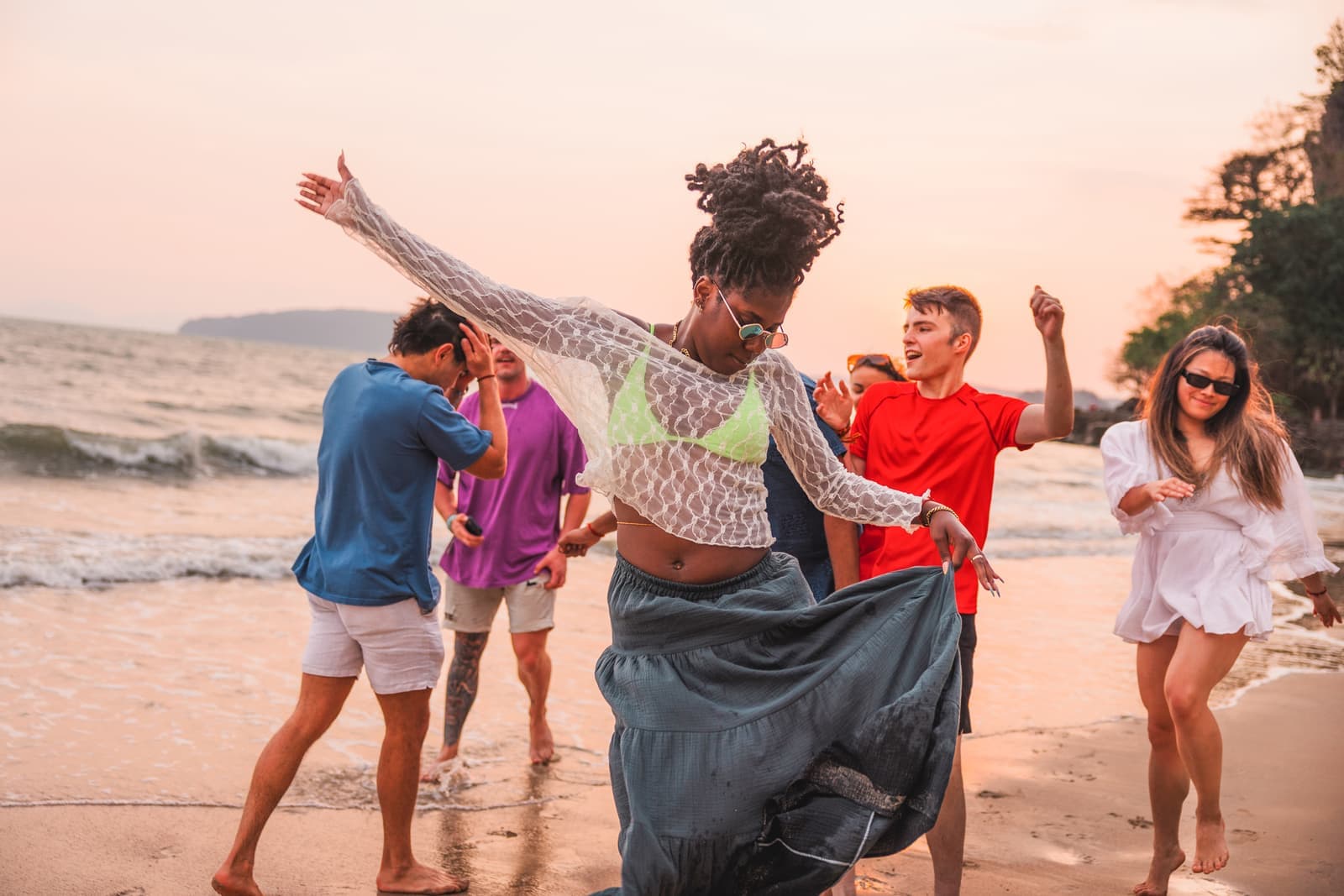 Travellers dancing on the beach at sunset, Krabi, Thailand
