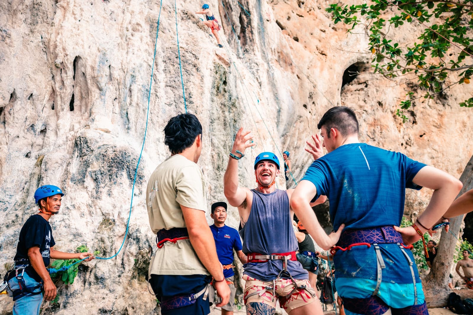 Travellers stood next to cliff and dressed in rock climbing equipment, Krabi, Thailand