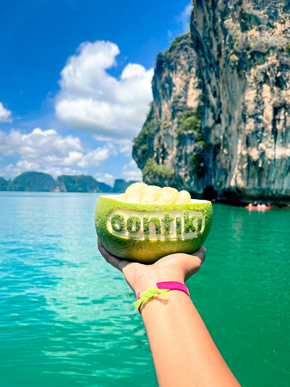 Fruit carved out with the Contiki logo with turquoise water in the background