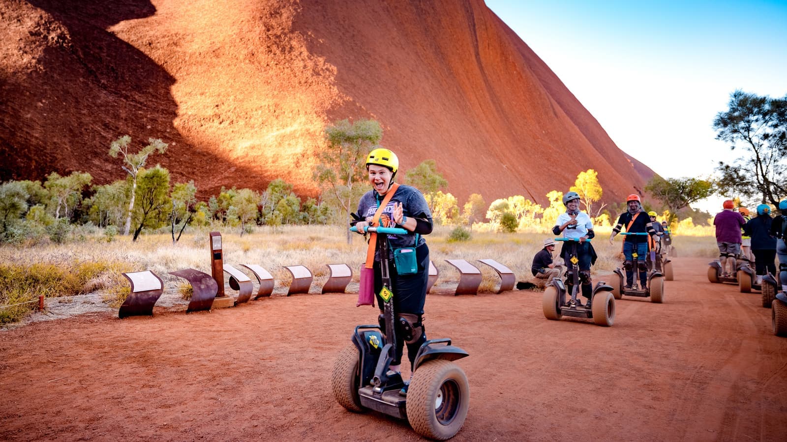 Travellers on a segway next to Uluru, Australia