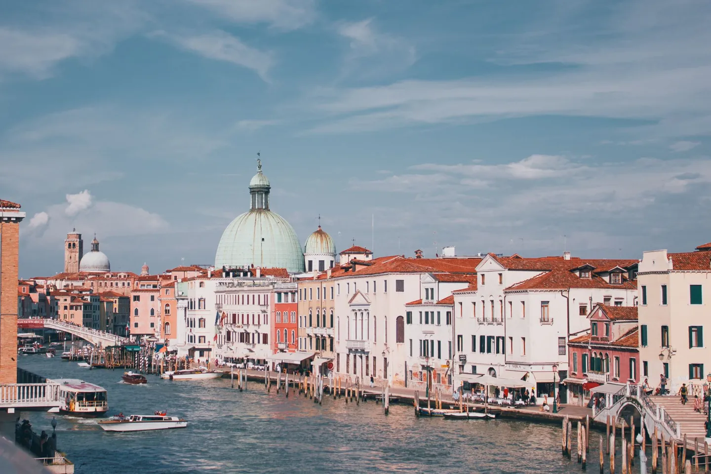 Canal lined with historic buildings and a green dome in Venice, a common Mediterranean embarkation port